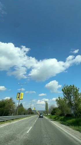 Vehicle travels sunny road in Byala, Bulgaria