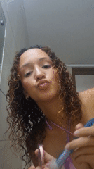 Woman applies makeup, takes bathroom selfie in pink attire