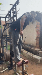 Man exercises barefoot on outdoor gym equipment in Akwanga