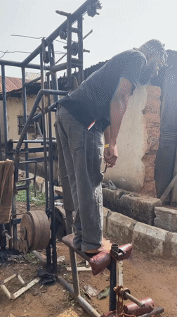 Man exercises barefoot on outdoor gym equipment in Akwanga
