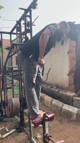 Man exercises barefoot on outdoor gym equipment in Akwanga