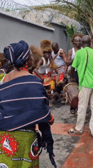 Outdoor gathering featuring elaborate headdresses and traditional dress