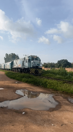 Graffiti-tagged train on a muddy track in rural Nigeria