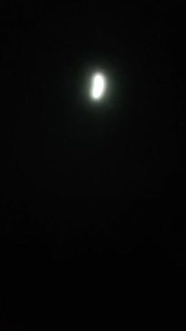 The video features a dark night scene with a bright full moon as the main light source. The focus is on the moon against the black sky. A distant, high-pitched howl or scream is heard in the audio.