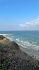 Surfers and boats along Netanya's coast on a calm morning