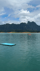 Backflip off a floating platform into a mountain lake