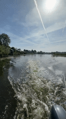 Small boat travels past waterfront homes in Leerdam canal