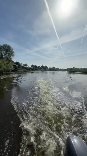 Small boat travels past waterfront homes in Leerdam canal