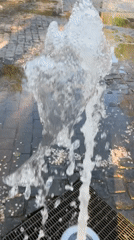 Child plays at fountain in Novokuybyshevsk park during afternoon