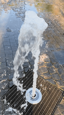 Child plays at fountain in Novokuybyshevsk park during afternoon