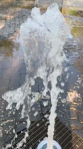 Child plays at fountain in Novokuybyshevsk park during afternoon