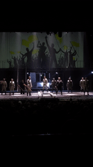 Theater performance features woman in white, military uniforms