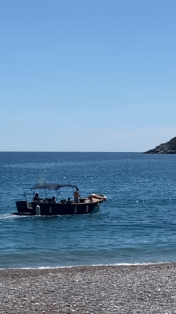 Tour boat operates near popular pebble beach in Prijevor, Montenegro