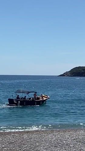 Tour boat operates near popular pebble beach in Prijevor, Montenegro