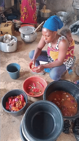 Woman prepares red peppers in kitchen with family present