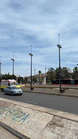 Valencia street scenes capture ambulance, blooming trees, construction activity