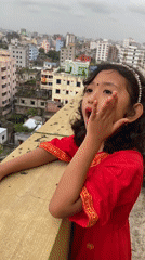 Rooftop dancing in traditional dress above Dhaka's dense skyline