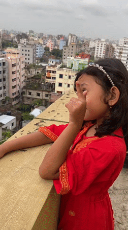 Rooftop dancing in traditional dress above Dhaka's dense skyline