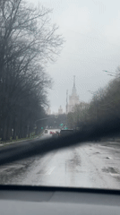 Driver captures wet Moscow street scene with spired building