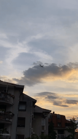 Aircraft filmed passing over Belgrade suburb during sunset