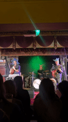 Three-piece band in jester hats performs live in London