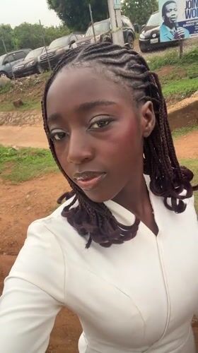 Woman photographed near campaign signs in Nigerian village