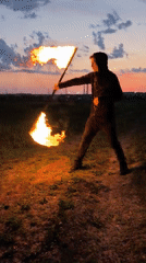Fire staff practice session captured at sunset in Russian field