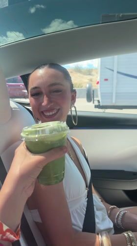Woman receives green drink in car, Thousand Palms