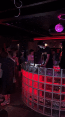 DJ performs for dancing crowd at Bangkok nightclub