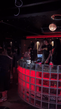 DJ performs for dancing crowd at Bangkok nightclub