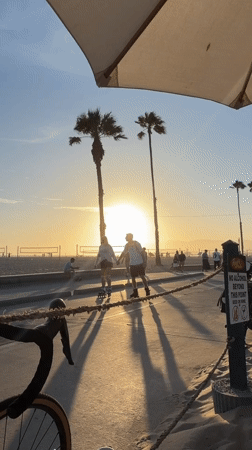 Santa Monica boardwalk at golden hour, bikes and palms