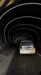 Driving through a futuristic lit tunnel in Manado