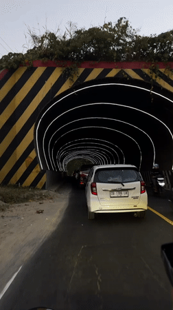Driving through a futuristic lit tunnel in Manado