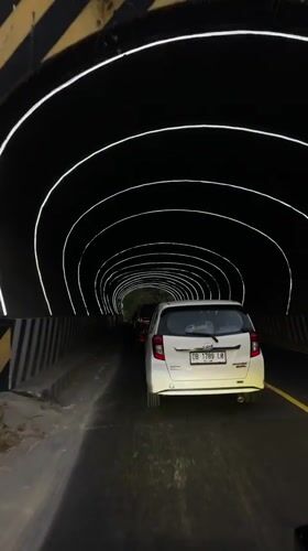 Driving through a futuristic lit tunnel in Manado