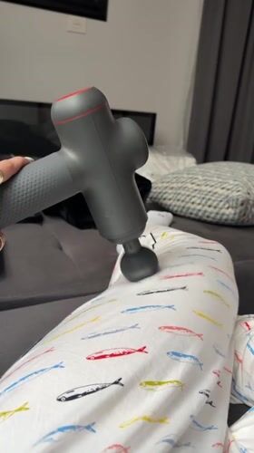 Person uses massage gun during late-night self-care session