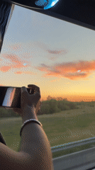 Bus passenger photographs sunset over Russian countryside fields