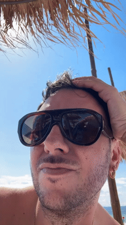 Family enjoys sunny afternoon at Greek beach, children catch fish