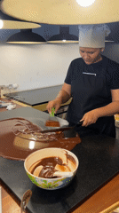 Chocolatier crafts and displays artisan confections in commercial kitchen