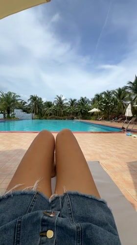Person relaxes poolside in Vietnam as child approaches water