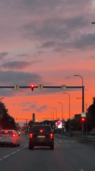 City street driving under a vivid dusk sky