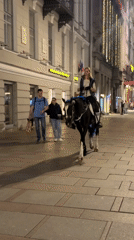 Woman rides decorated horse through Saint Petersburg streets at dusk