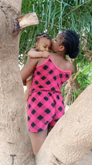 Woman plays with baby in outdoor yard in Keffi