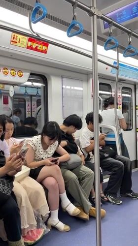 Child sleeps on passenger's lap in Jiulongpo subway car