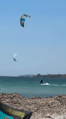 Kitesurfers launch and ride off a seaweed-lined Lemnos beach