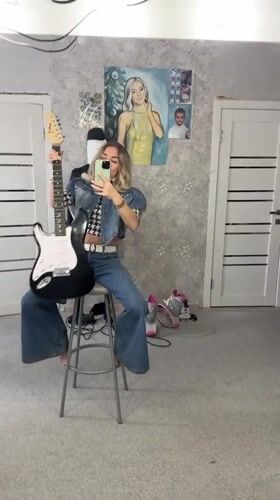 Woman films guitar content in Abakan indoor session