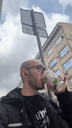 Man with glasses filmed on Moscow street during overcast morning
