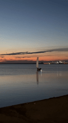 Sailboat on calm Kazakh lake waters at dusk