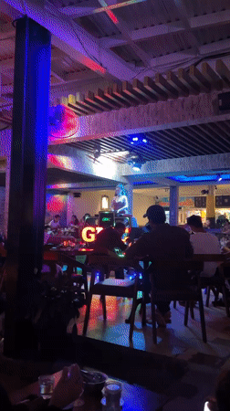 Red-dressed performer entertains diners at Nha Trang restaurant-cafe