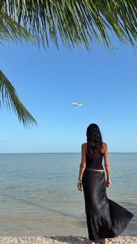 Quiet Ko Samui coastline: beach, boat, and a passing plane