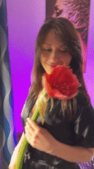 Woman poses with red flowers in Murino apartment photoshoot